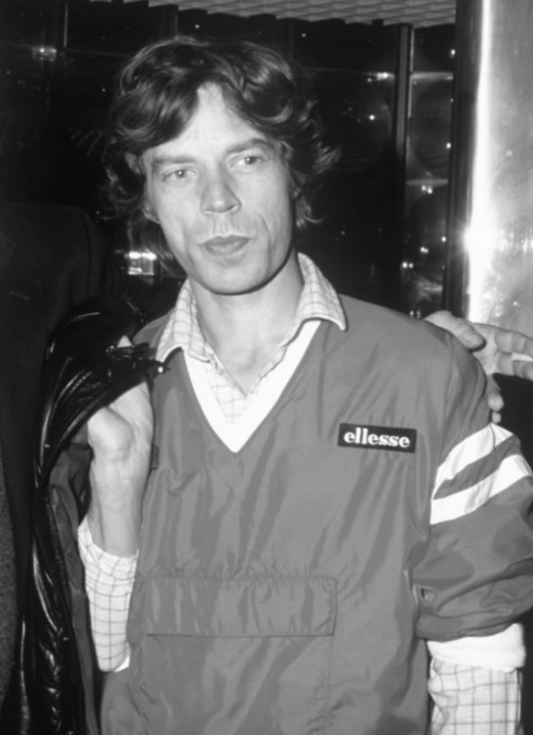 Mick jagger wearing a ellesse jacket with a blurred background