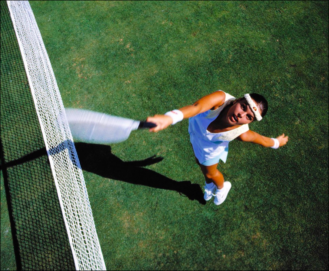Woman in Ellesse tennis apparel on a clay court